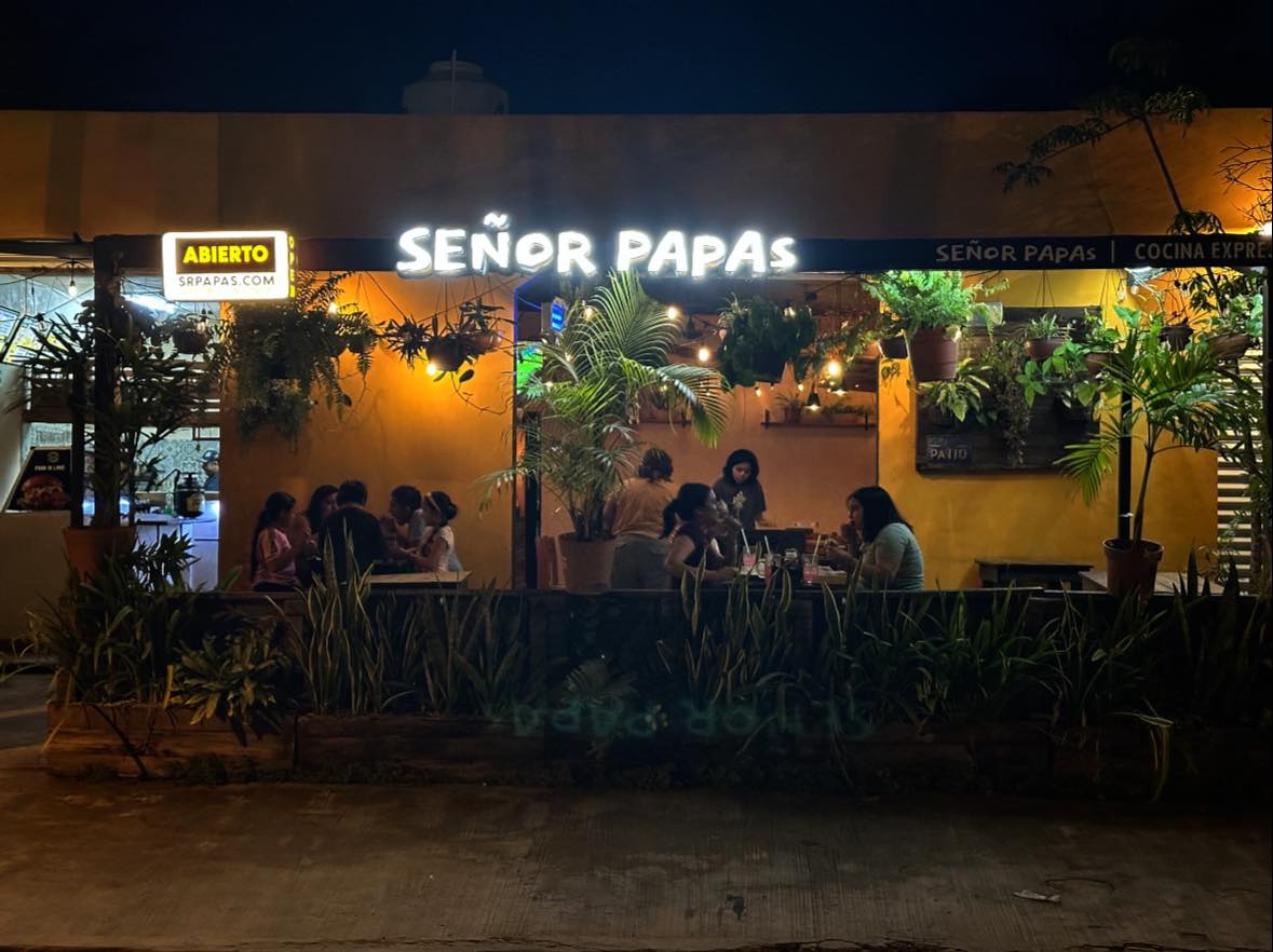 Restaurant exterior at night with customers